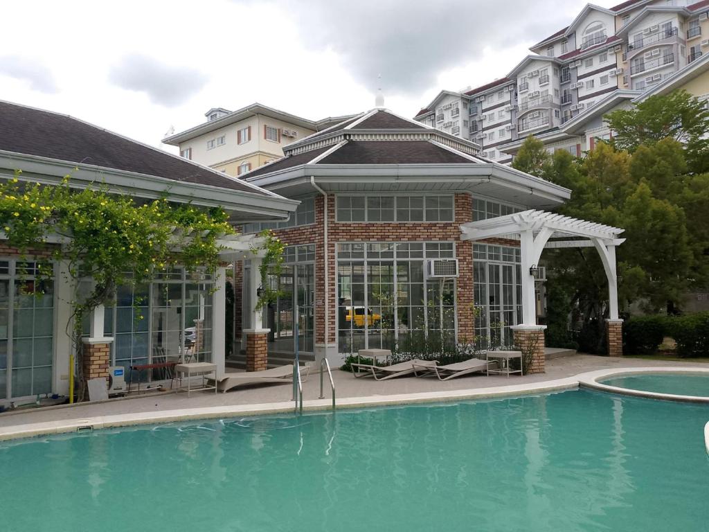 ein Haus mit einem Swimmingpool vor einem Gebäude in der Unterkunft Apple One Banawa Heights in Cebu City