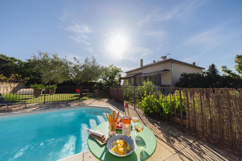 une table avec de la nourriture dessus à côté d'une piscine dans l'établissement Villa en Luberon, climatisé, Piscine, wifi et Parking gratuit, à Bonnieux