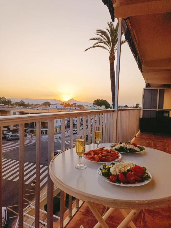 a table with two plates of food and drinks on a balcony at Sunny Balcony in Oliva