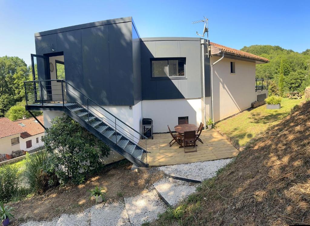 a house with a balcony and a table on a hill at Egoitza apartment near Guethary in Saint-Jean-de-Luz