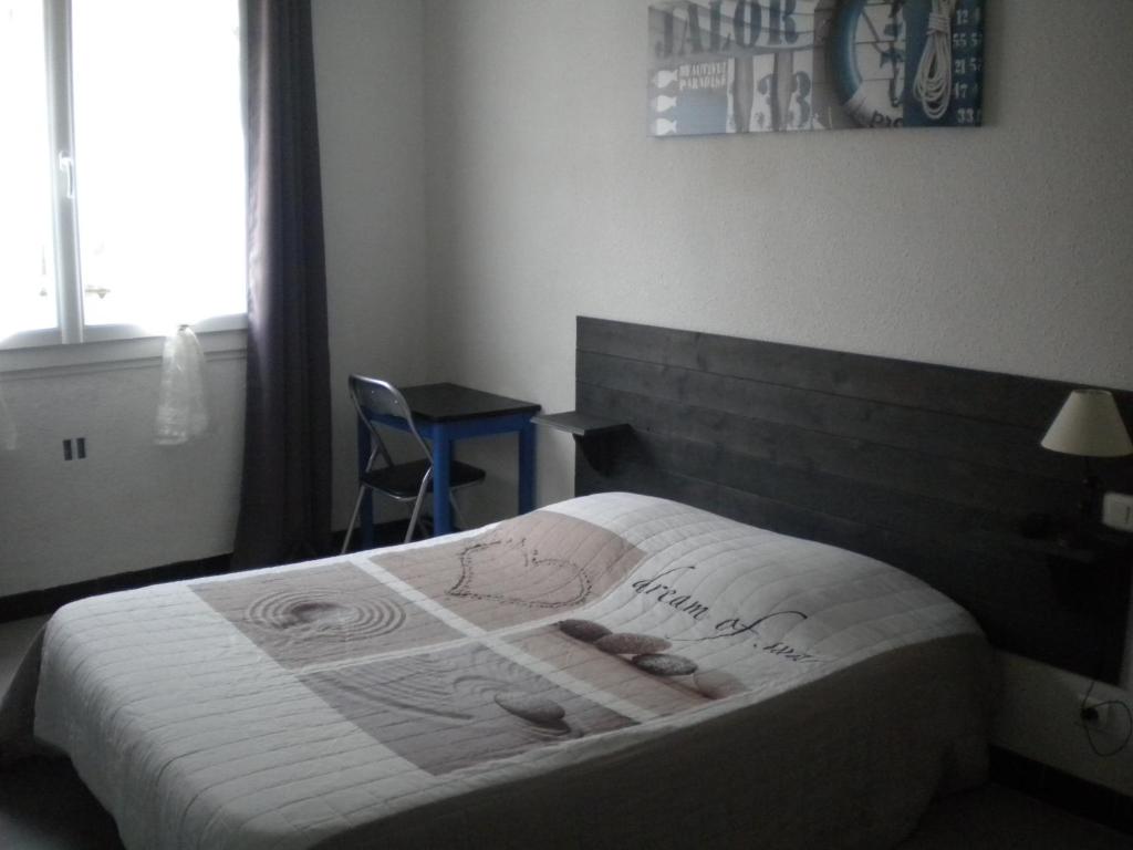 ニッサン・レ・アンサリューヌにあるL 'Acropoleのベッドルーム1室(白い掛け布団、靴付)