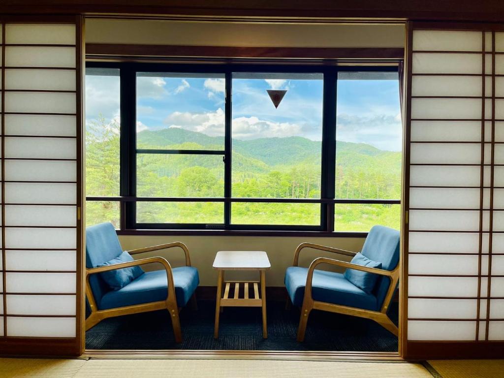 a room with two chairs and a table and a window at Kurobe Sun Valley Hotel - Vacation STAY 90881v in Omachi