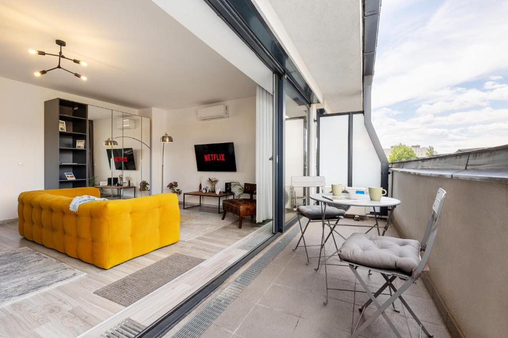 a living room with a yellow couch and a table at Magnolia Apartment Hotel in Budapest