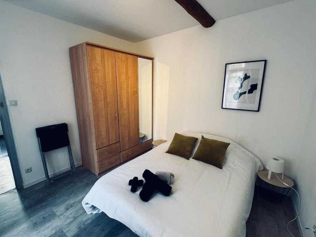 una camera da letto con un letto bianco e due orsacchiotti sopra di Chambre Saint-Nazaire 3e Etage a Béziers