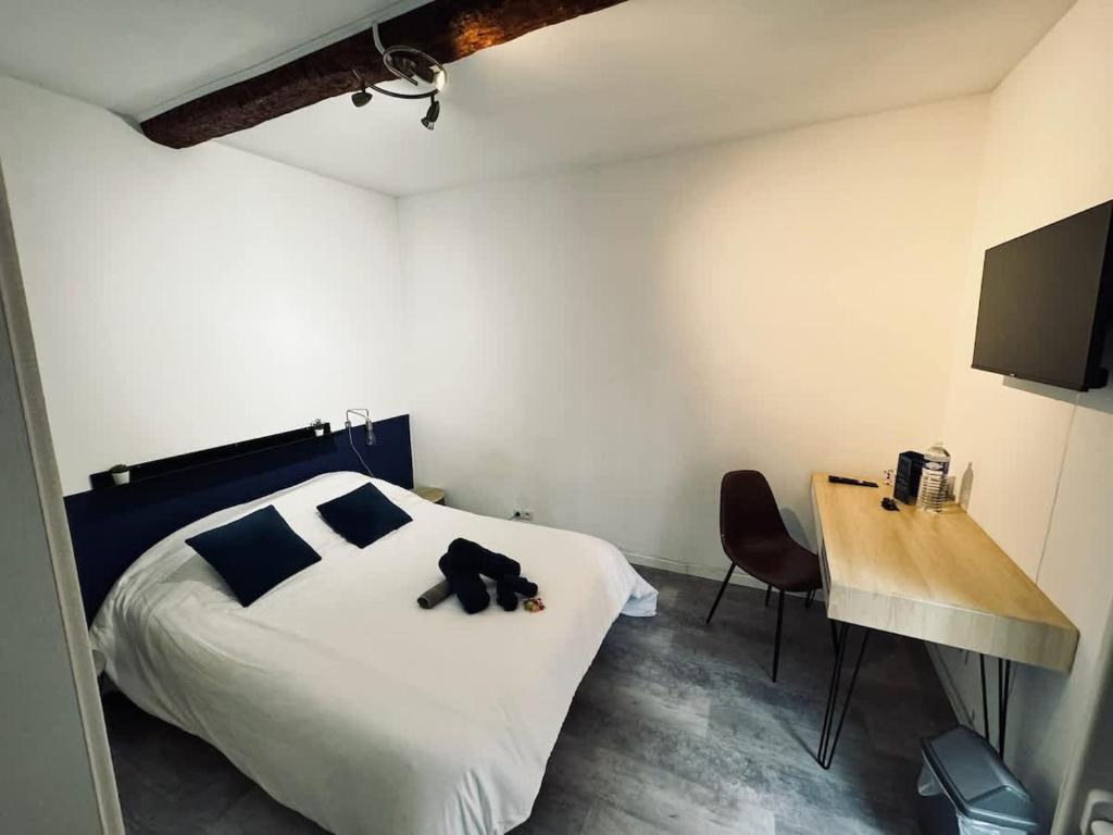 une chambre avec un ours en peluche noir sur un lit dans l'établissement Chambre Orb 1 etage, à Béziers