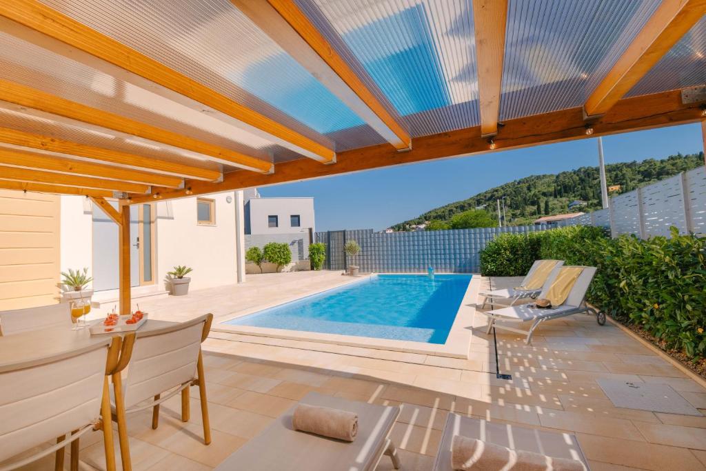 a swimming pool in a villa with a patio at A'More Preko in Preko
