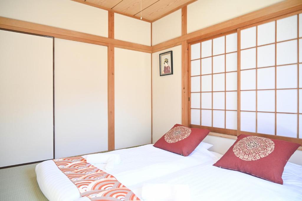 two beds in a room with windows at Asakusa Ginza direct access to the airport in Tokyo