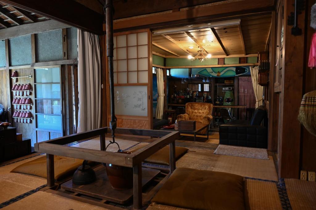 un soggiorno con tavolo al centro di una camera di 星が綺麗な町の古民家 Kominka いすみ市 a Shiigi
