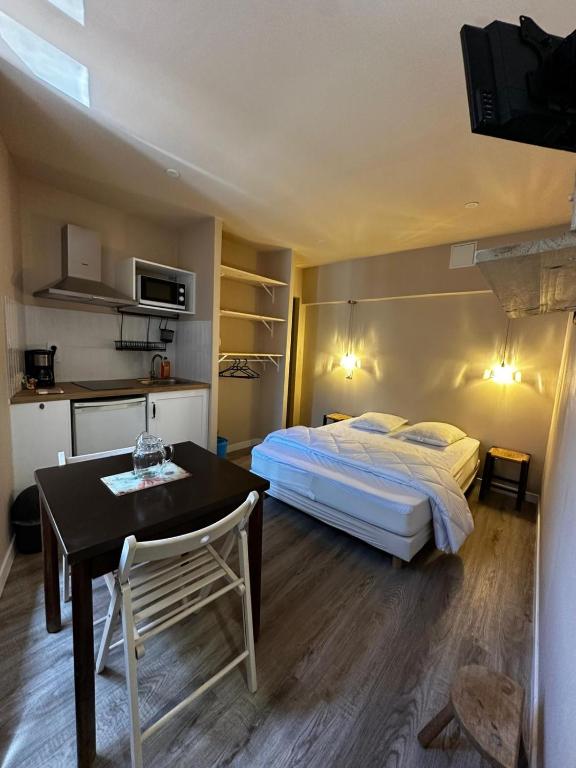 a bedroom with a bed and a table and a dining room at Studio 3 Aux volets bleus in Aulus-les-Bains
