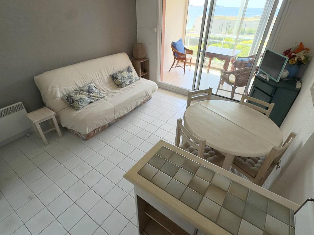 un salon avec une table et un canapé dans l'établissement T2 + coin nuit - Mer, Piscine, Tennis, Parking à 200m des Plages/Commerces - FR-1-316-287, à Six-Fours-les-Plages