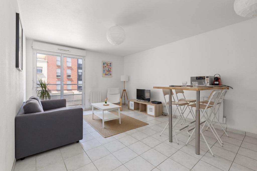 una sala de estar con un sofá y una mesa en Grand appartement Rouen Free Parking Privé Gratuit, en Rouen