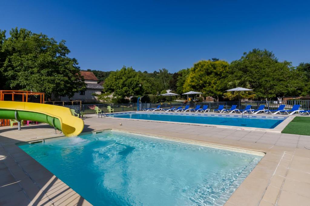 une piscine avec un toboggan au milieu dans l'établissement Cottage 6 personnes climatisé, à Saint-Martial-de-Nabirat