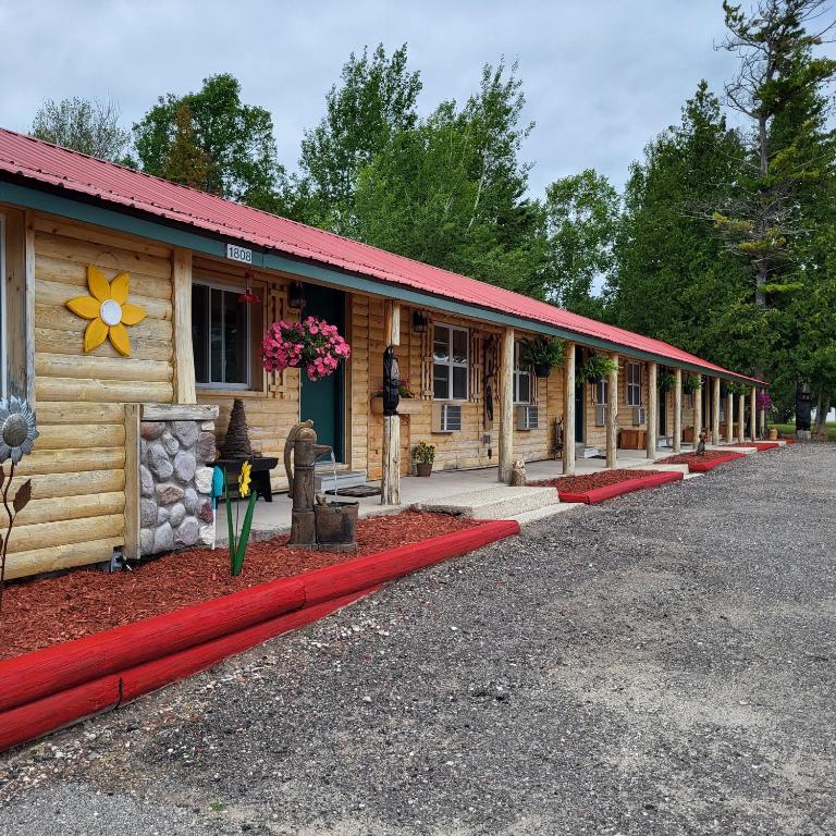una fila di edifici in legno con vernice rossa sopra di Moosewood Inn a Saint Ignace
