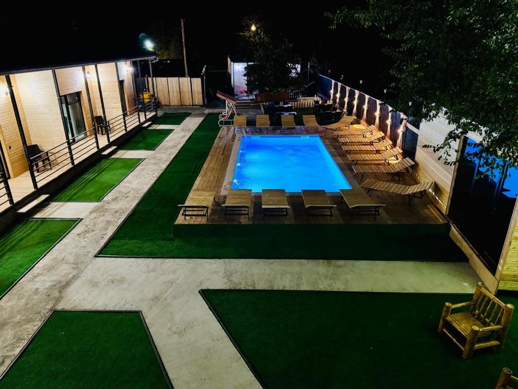 an overhead view of a swimming pool with chaises and chairs at 13th Turn in Borjomi
