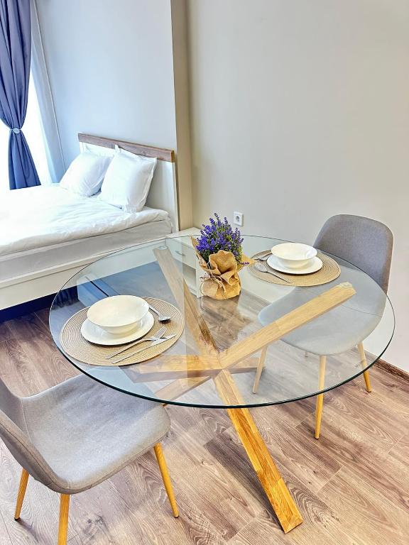 a glass table with two chairs and a couch at Chantrer in Burgas