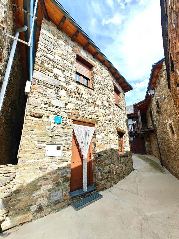 kamienny budynek z drzwiami na boku w obiekcie Casa el Tejo w mieście San Cristóbal de Valdueza