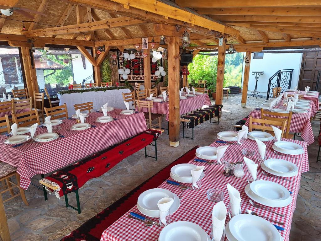 un ristorante con tavoli e sedie rossi e bianchi di Etno selo Lelić a Valjevo