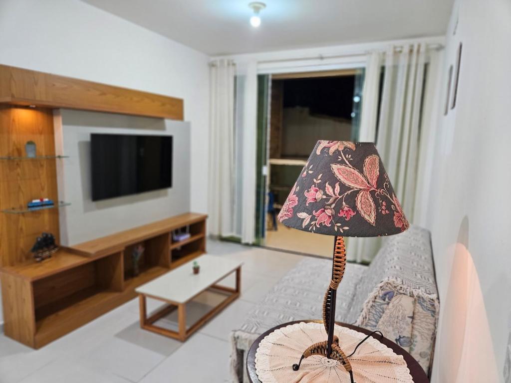 una lampada posta in un soggiorno con un televisore di Apartamento em Cabo Frio a Cabo Frio