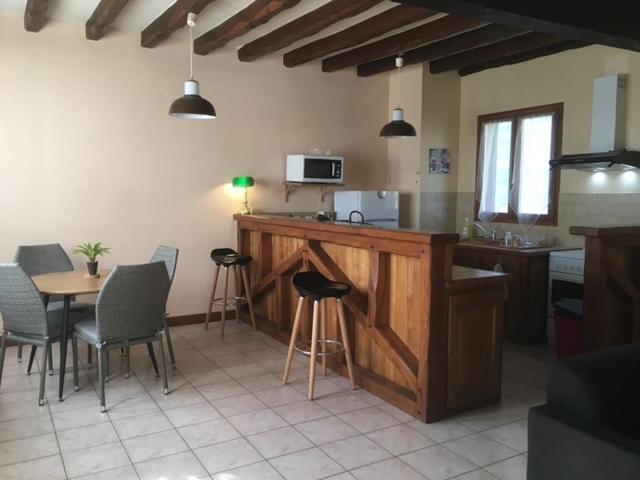 Una cocina con encimera, mesa y sillas. en Etape cocooning, en Villefranche-Saint-Phal