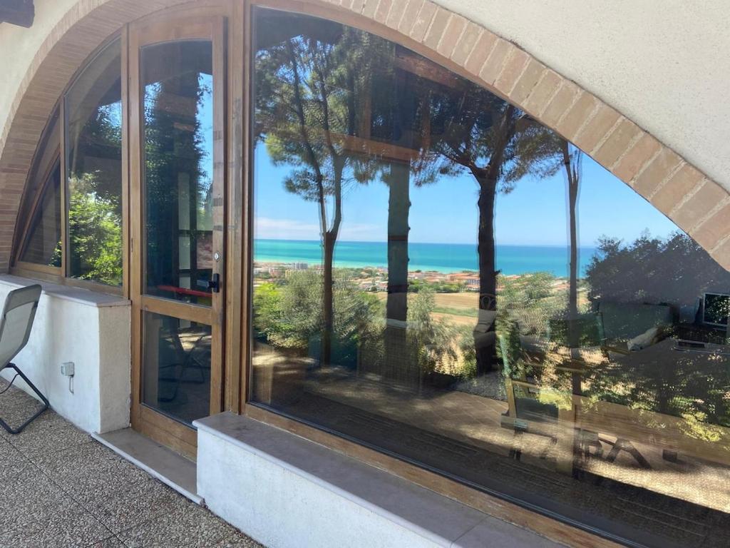 a room with a window looking out at the ocean at Beautiful loft between the sea and the woods in Marcelli