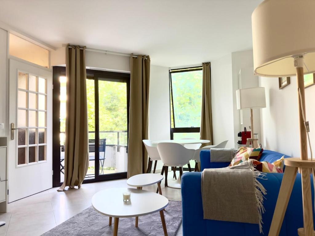 a living room with a blue couch and a table at Spacious new studio and terrace in Juan-les-Pins