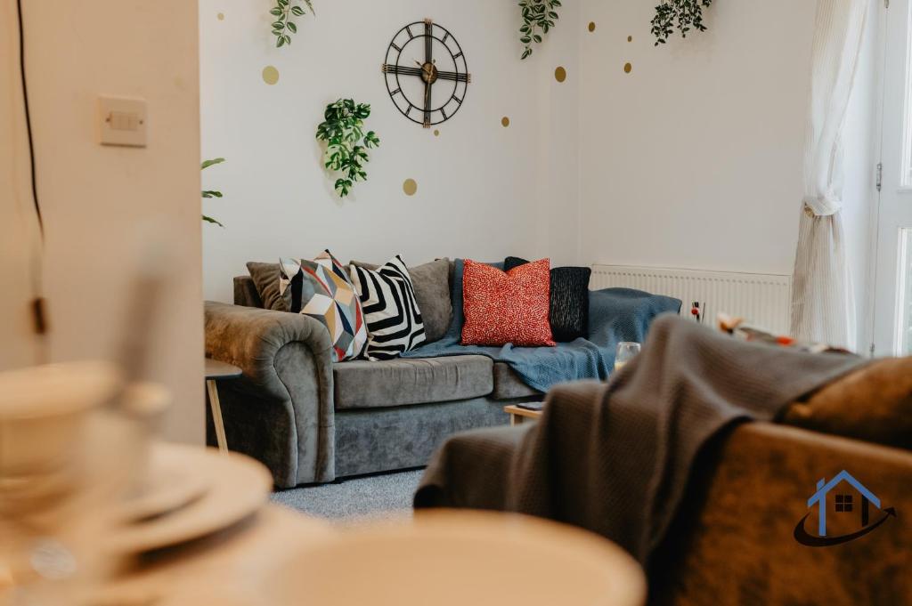 a living room with a couch with pillows on it at 4 Clovelly Court, Derby, DE22 1GS in Derby