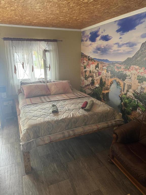 a bedroom with a bed with a painting on the wall at Motel Capljina in Čapljina
