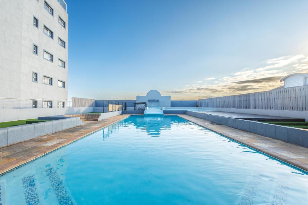 una piscina di fronte a un edificio di Elegant Emerald Stay at Ridgeton Modern Two Bedroom Apartment in the Heart of Umhlanga Ridge Sleeps 6 a Durban