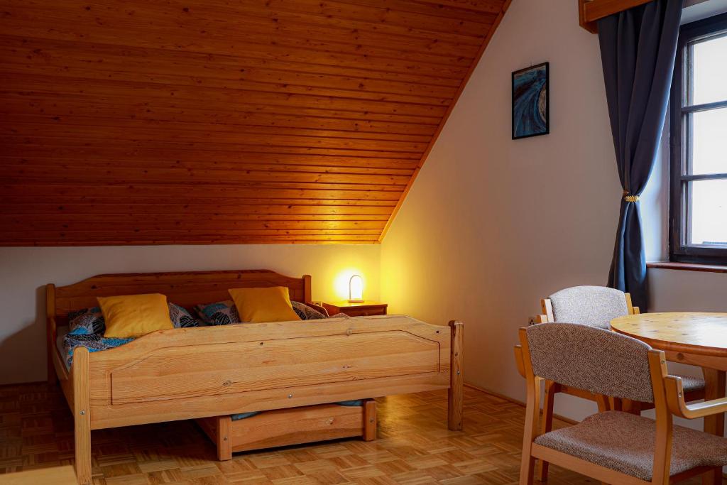 a bedroom with a bed and a table and chairs at Ubytování U Anděla in Raby