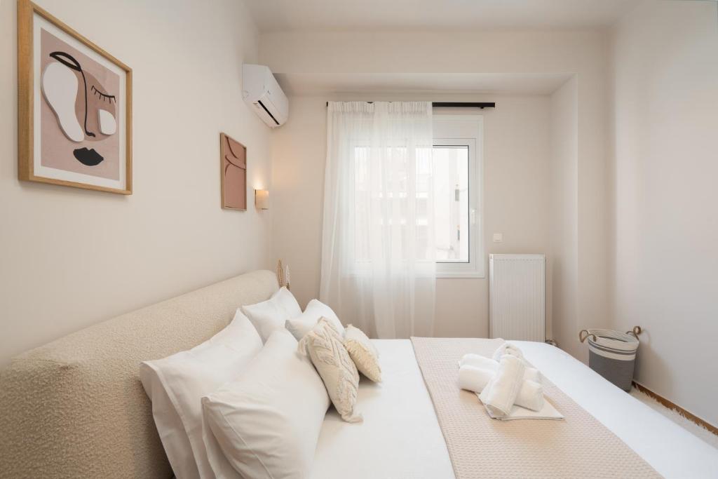 ein weißes Schlafzimmer mit einem Bett mit weißen Kissen in der Unterkunft RoomsByRamez -Chill Bright Stay- -Central Athens- in Athen
