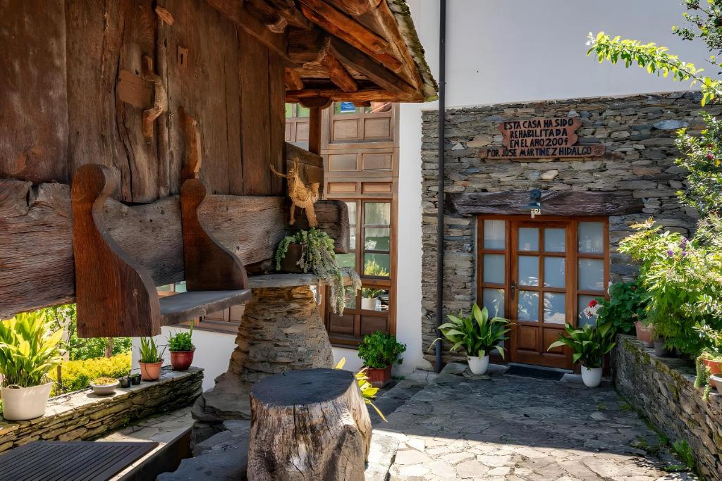 a building with a wooden door and some plants at Puente del Narcea 3 in Cibuyo