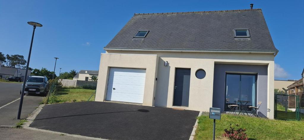 una casa blanca con dos puertas de garaje en una calle en La Belle Paimpolaise, en Paimpol