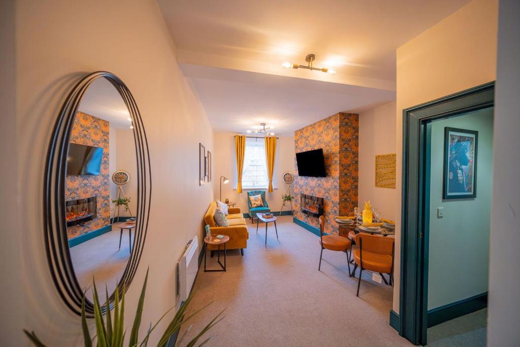 a living room with a mirror and a living room with a couch at 2 Bed Newly refurbished apartment, Free Parking, Pet Friendly in Gloucester