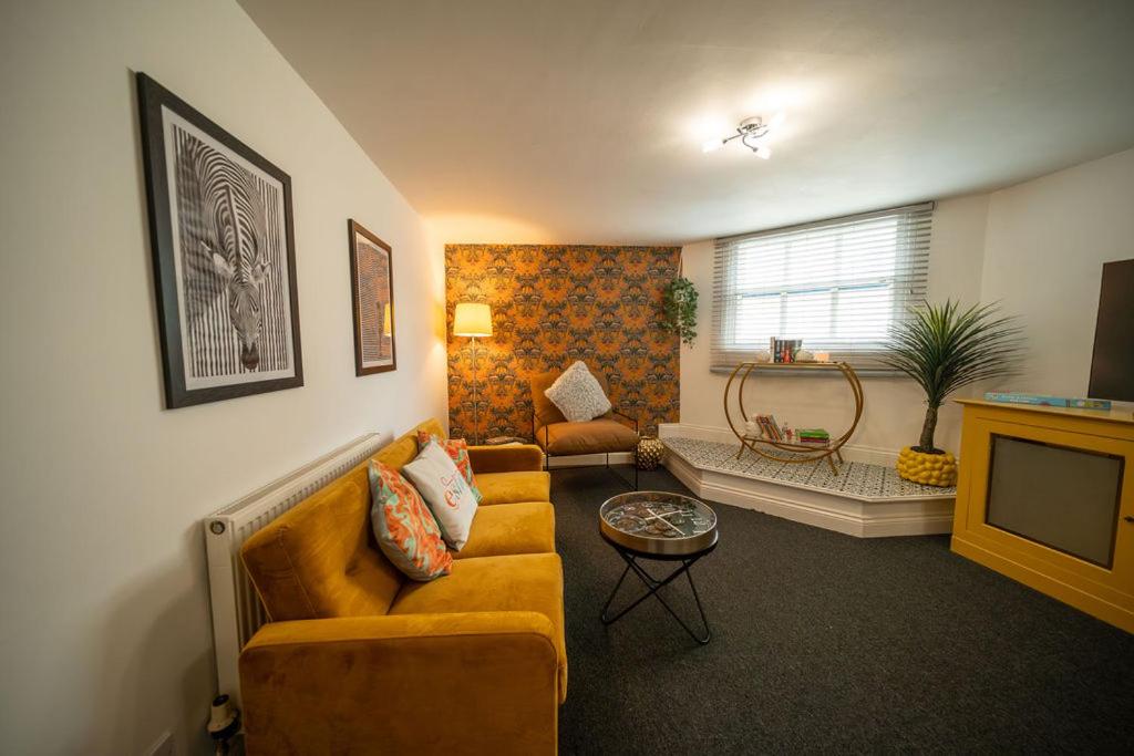 a living room with a couch and a tv at Cotswolds, 2Bed 1 Bath Historic Flat, Very Central in Cirencester