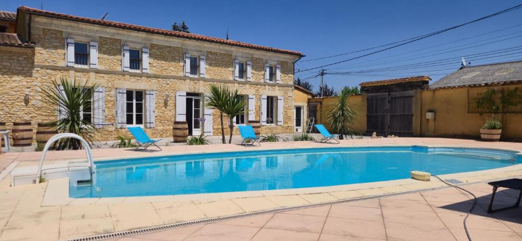 une maison avec piscine devant un immeuble dans l'établissement La Résidence du Vignoble L'Homme Cheval, à Anglade