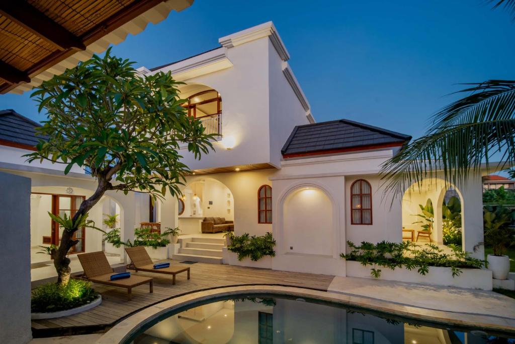 a villa with a swimming pool at night at Hastana Villa in Sukawati