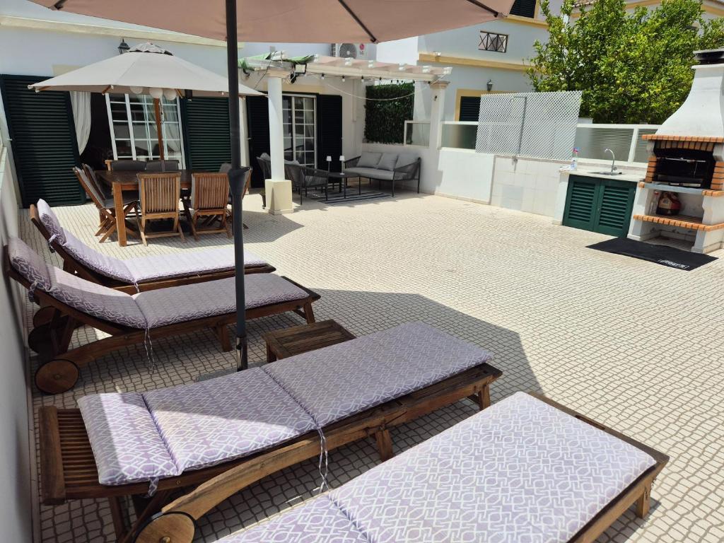 een terras met een tafel, stoelen en een parasol bij Manta Azul in Manta Rota