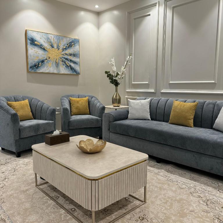 a living room with two couches and a coffee table at شقة مميزة بتصميم حديث in Baljurashi