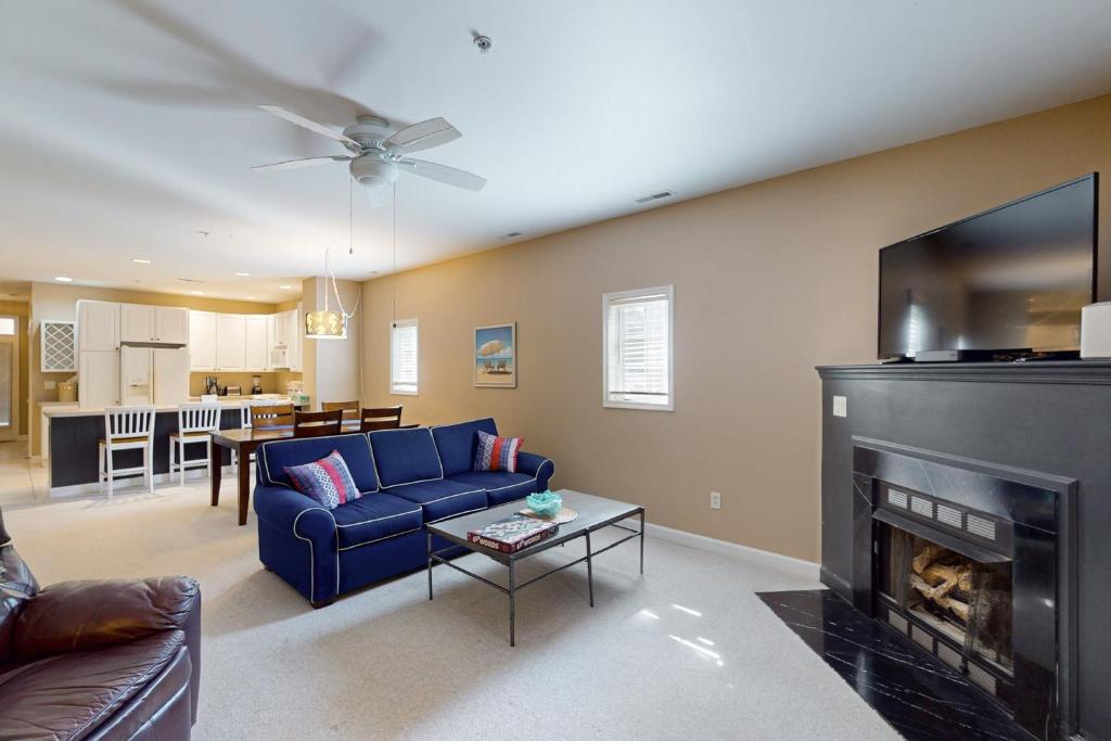 a living room with a blue couch and a fireplace at Summerlyn --- 34297 Summerlyn Dr, Apt 501 in Lewes