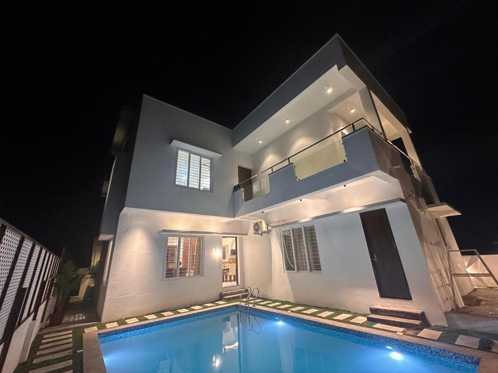 a house with a swimming pool in front of it at night at Extasea Beach Villa in Cheyūr
