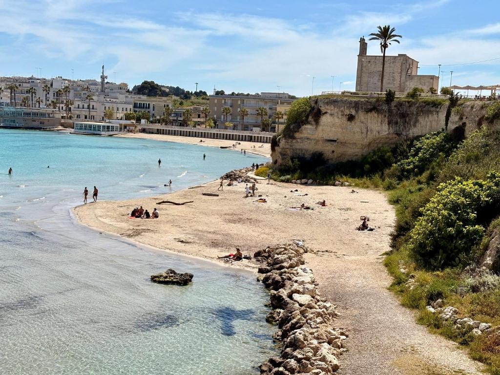 a group of people on a beach near the water at Portico dei Gradoni by Alma Dimore in Otranto