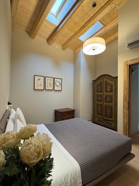 a bedroom with a bed with a vase of flowers at La Maison du Lac Iseo 3 in Predore
