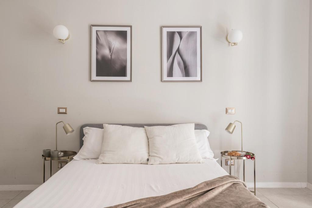ein Schlafzimmer mit einem Bett mit zwei Bildern an der Wand in der Unterkunft The Best Rent - Bright flat near San Pietro in Rom