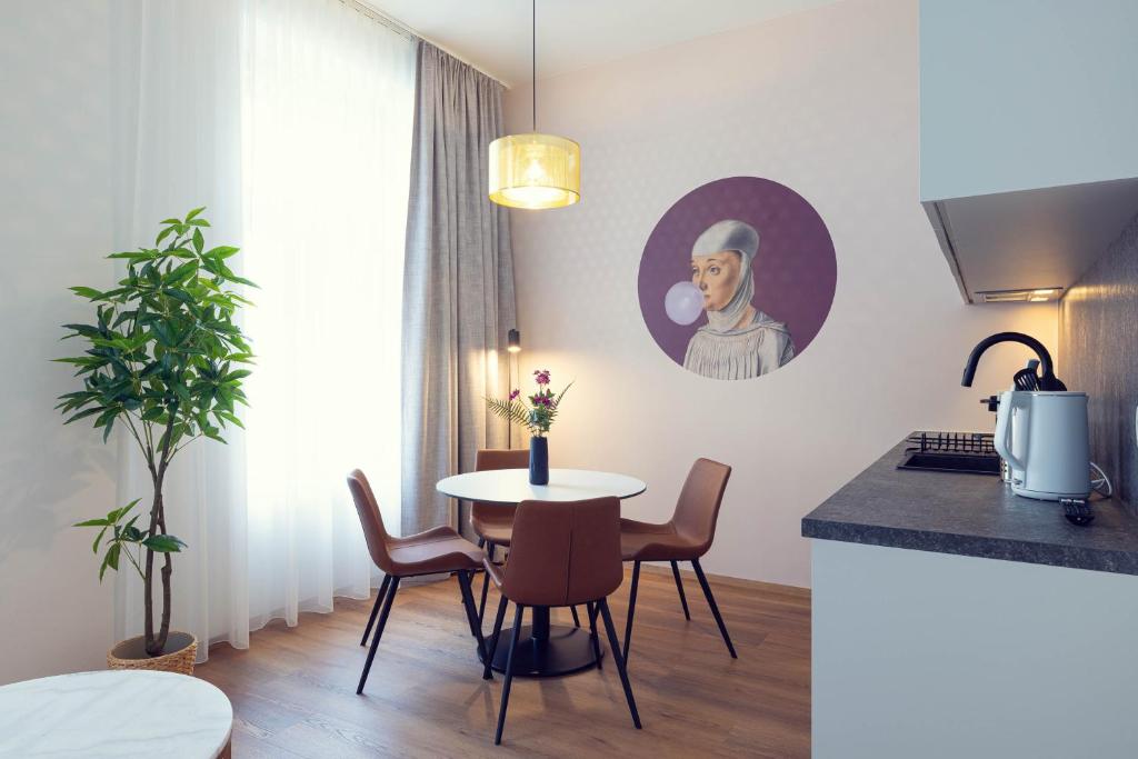 a kitchen and dining room with a table and chairs at LeonArt Living 24 in Graz