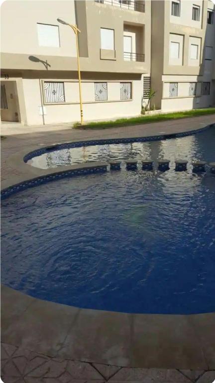a large pool of water in front of a building at Beau appartement à saidia in Saïdia