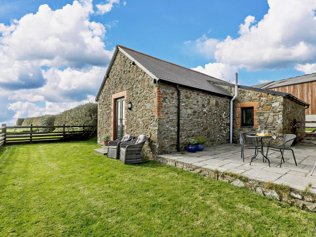 un granero de piedra con patio y césped en 1 Bed in Hartland LINNE, en Hartland