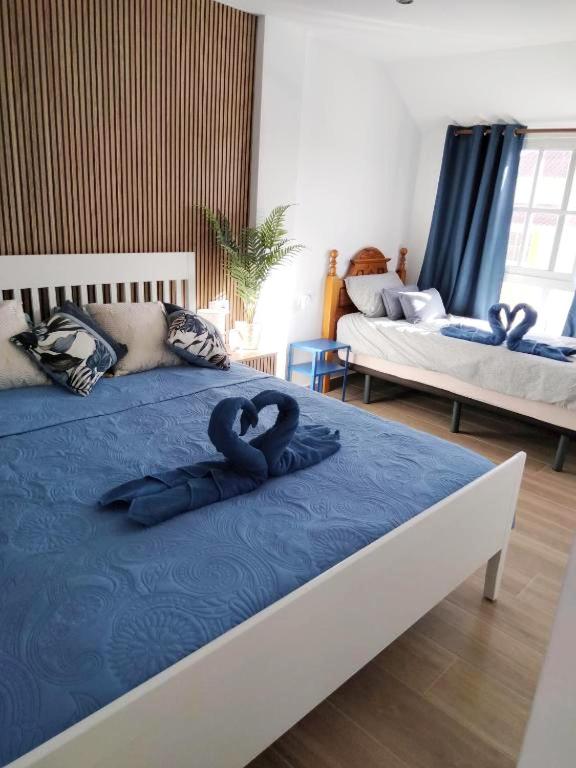 a bedroom with a bed with two heart pillows on it at Casa MACON BLUE in Caleta De Fuste