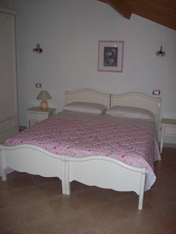 a bedroom with a white bed with a pink blanket at Santa Maria 2 in Mendicino