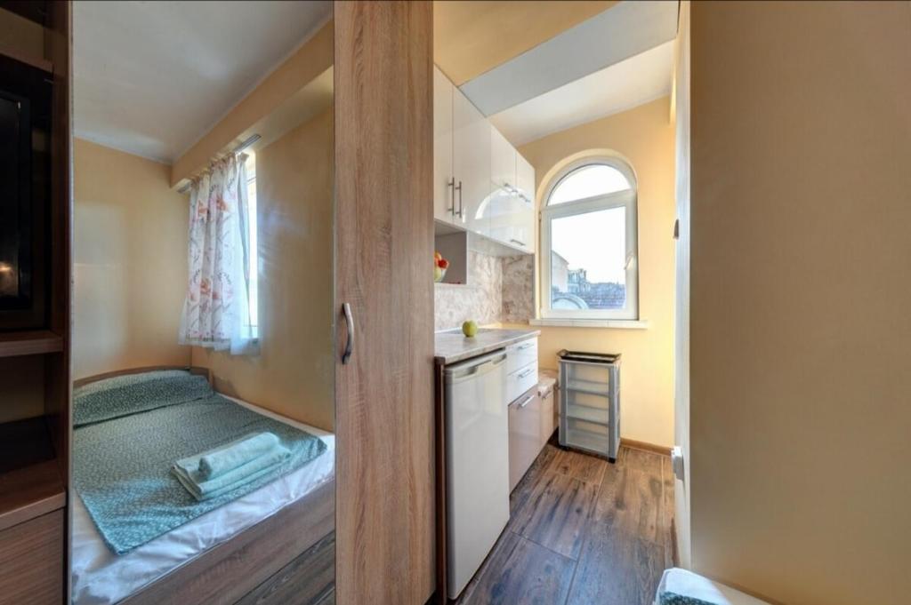 a small room with a bed and a kitchen at Funny-Gunny Room to The Sea Garden in Burgas City