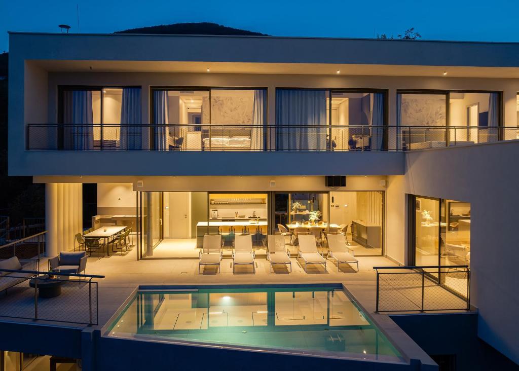 a large house with a swimming pool in front of it at Villa Ladeti Sereno in Poljane